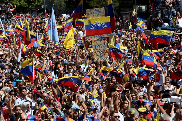 People wave Venezuelan flags during a demonstration.