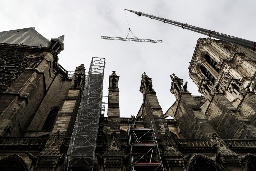 A crane lifts scaffolding to the roof of the cathedral.