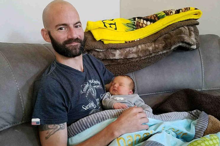 Derek Rotondo poses with his baby.