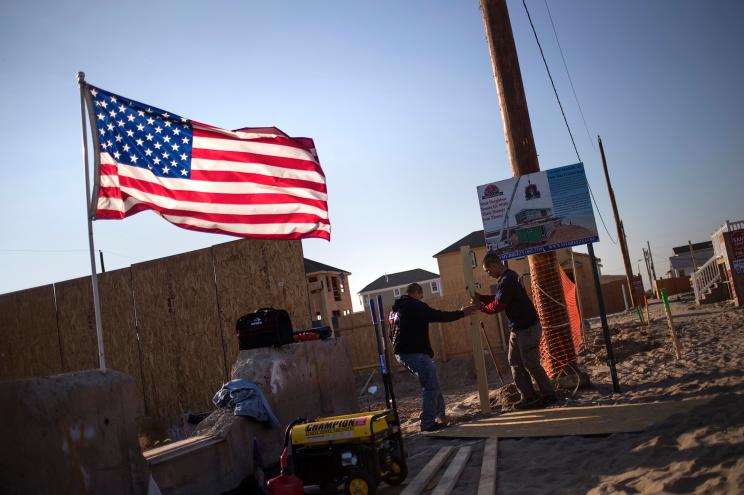 Workers create a plywood cover around a lot which was left damaged by Hurricane Sandy on the one-year anniversary of the storm in Breezy Point, New York