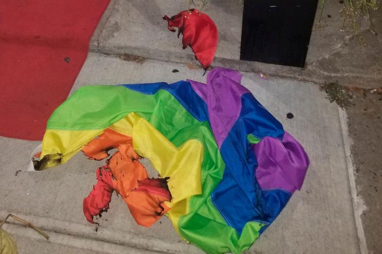 A burned rainbow flag lays on the stoop of the Alibi Lounge