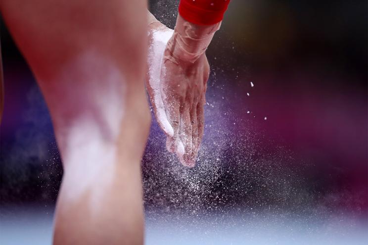 A US gymnast rubs her hands with chalk before doing a routine