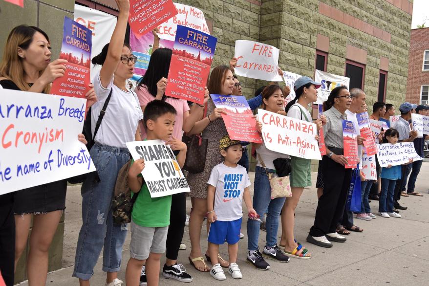 Asian Americans protesting Richard Carranza, holding signs claiming he is racist.