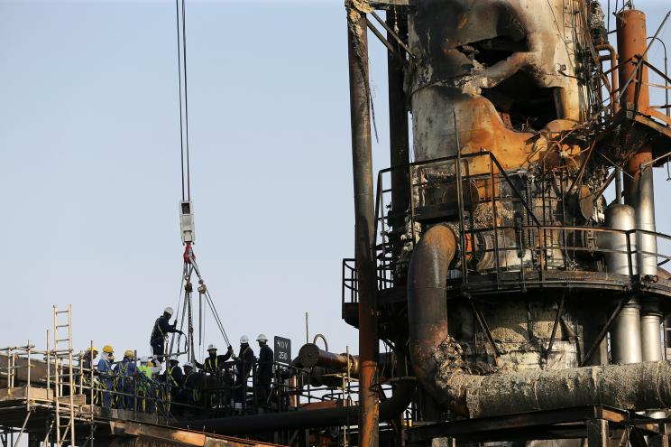Workers at the damaged site of Saudi Aramco oil facility in Abqaiq, Saudi Arabia