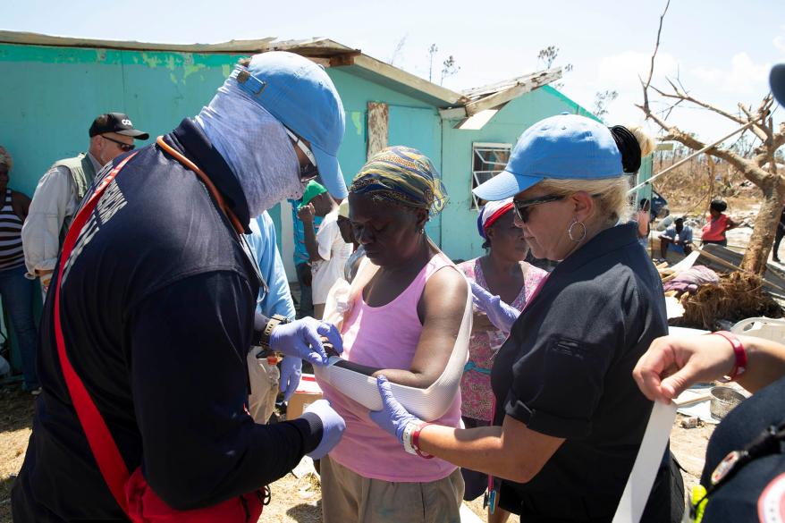 A woman receives medical help from a Search and Rescue Team from the Emergency in the Bahamas.