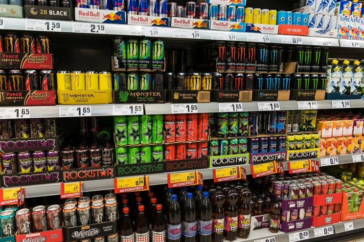 Stacks of energy drinks on a store shelf.