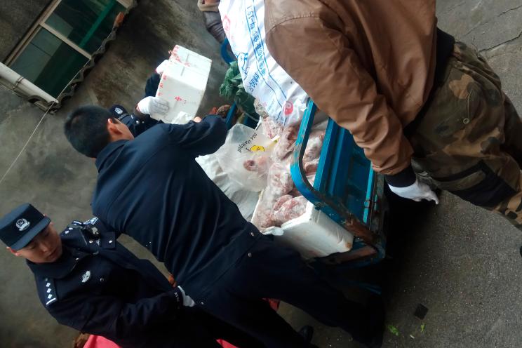 Police load a cart with items seized from a store suspected of selling trafficked wildlife are seen in Anji city in eastern China's Zhejiang Province.