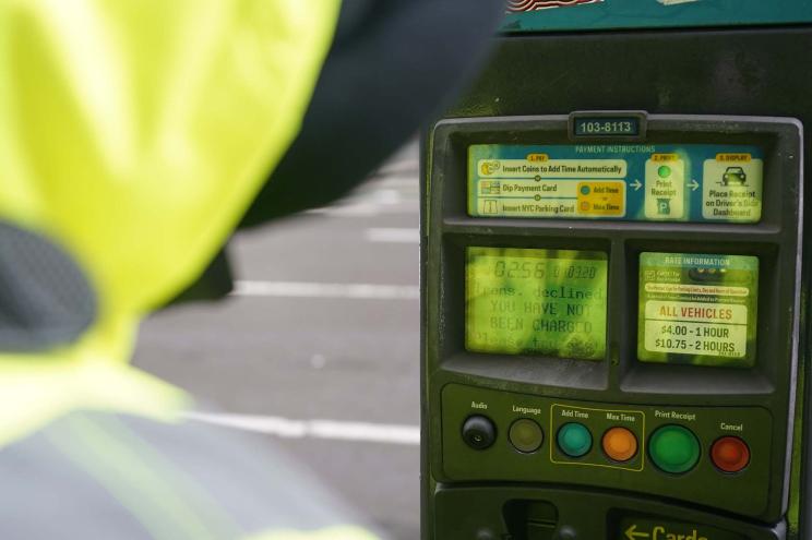 Two workers reset parking meter to accept credit cards