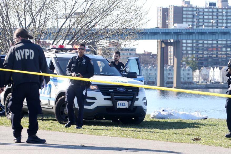 Police near the body that was discovered in a crowded Little Bay Park in Queens today.