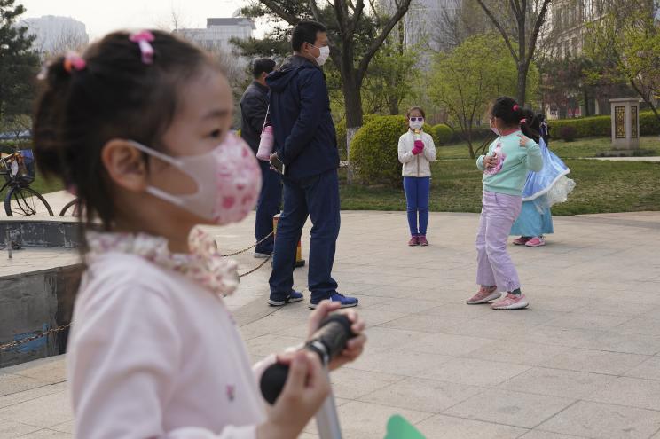 Young Chinese children wear protective masks as they playing in the garden on March 31, 2020 in Beijing, China