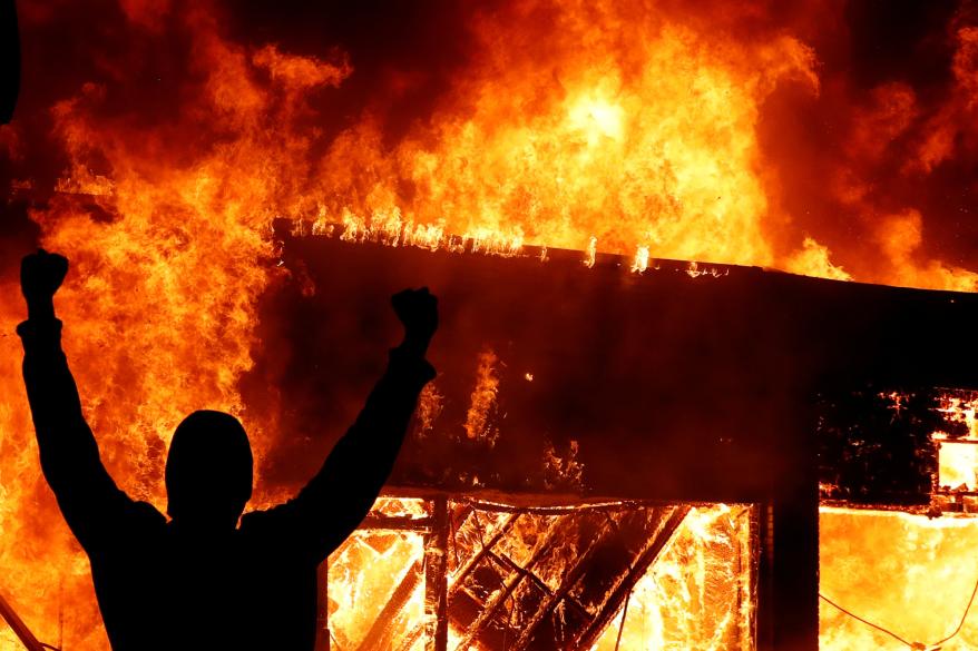 A protester gestures in front of a fire during the protest against the death of George Floyd in in Minneapolis, Minnesota.