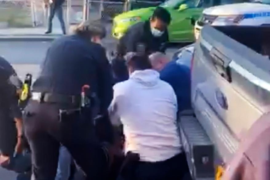 A still from a video taken showing an NYPD using force to arrest for social distancing violations.