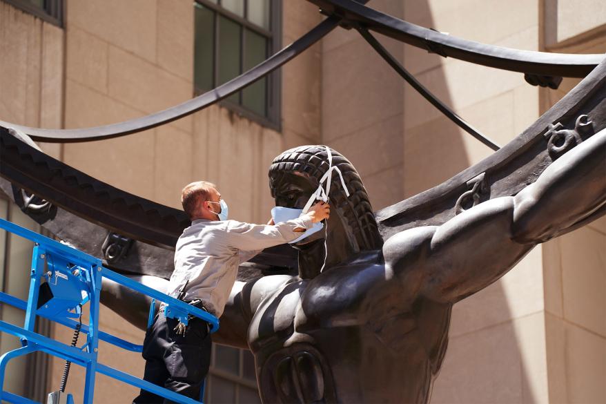 Engineer Val Ziba places a mask on the Atlas statue