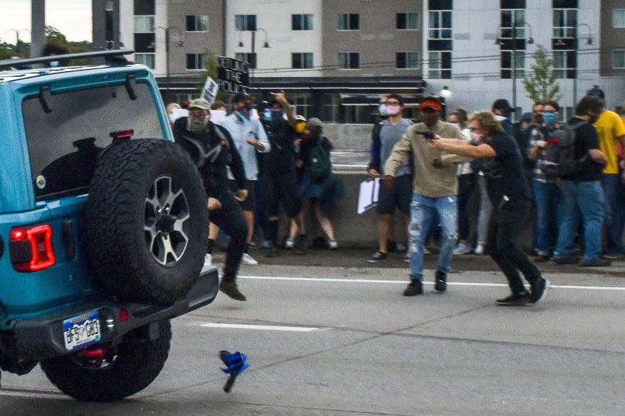 People run to get out of the way as a Jeep speeds through a crowd of people protesting the death of Elijah McClain on Interstate 225 in Aurora, Colorado.