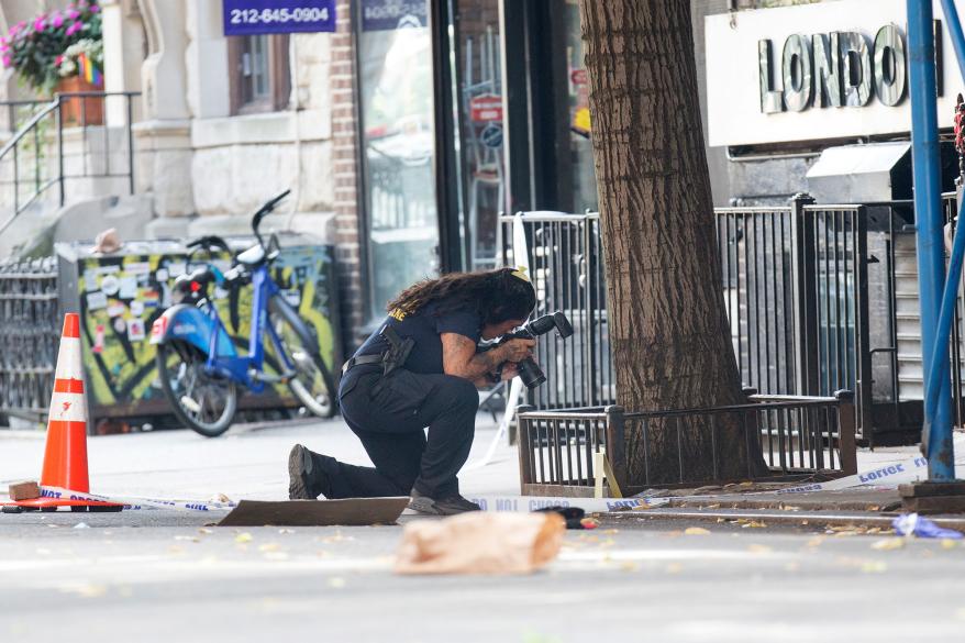 Crime Scene investigator taking photos at the scene of a shooting in the West Village today.