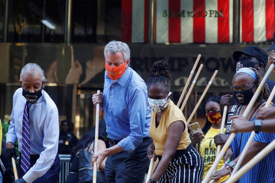 New York City Mayor Bill de Blasio, his wife Chirlane Irene McCray and Reverend Al Sharpton paint "Black Lives Matter" along 5th avenue