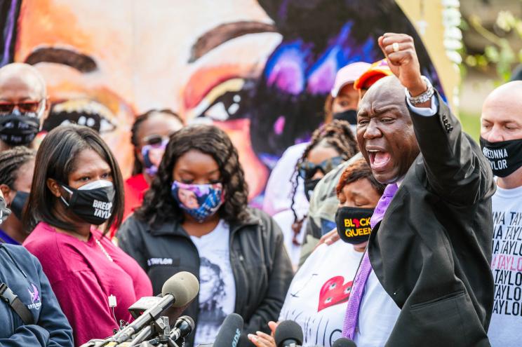 Attorney Ben Crump (right) leads a chant during a press conference at Jefferson Square Park in Louisville, Kentucky