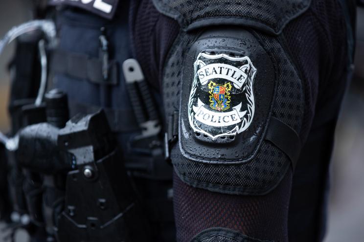 A Seattle Police Department can be seen on an officer's sleeve.