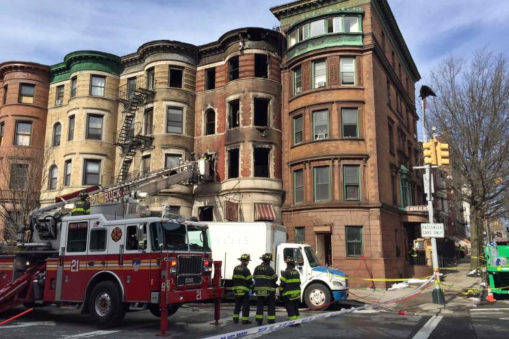 Firefighters work at the scene of a fire Friday, March 23, 2018 that began overnight in the Harlem neighborhood of New York.