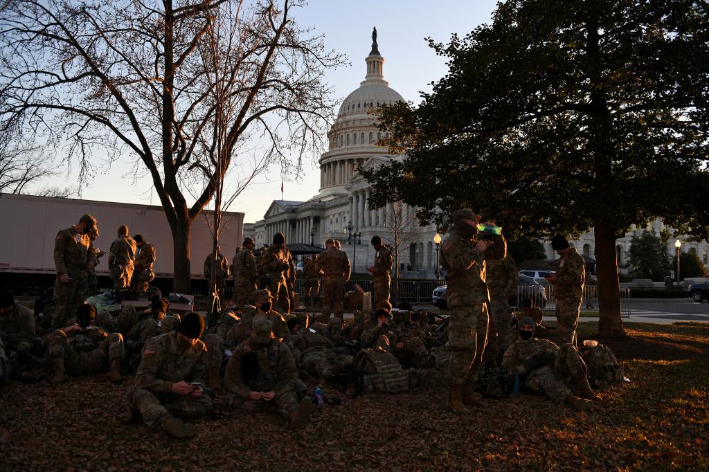 National Guard troops rest on a yard in front of the Capitol ahead of Joe Biden's inauguration on Jan. 19, 2021.