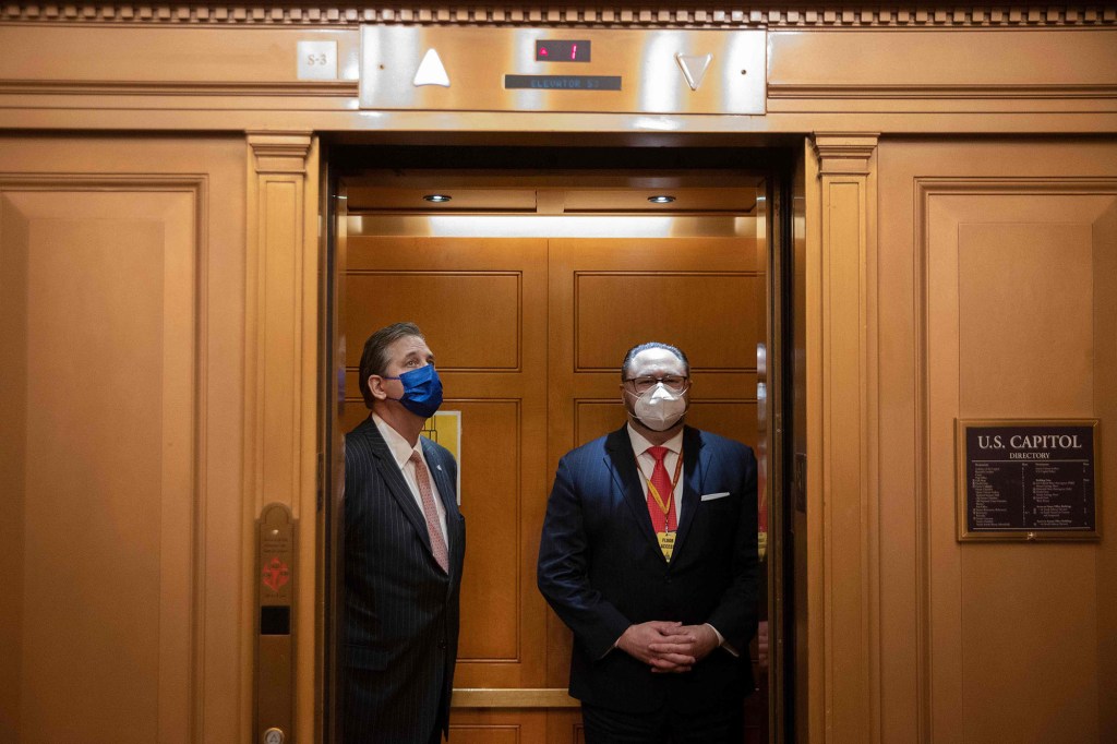 Bruce Castor (left), a defense lawyer for former President Donald Trump, boards an elevator in the Capitol on the first day of Trump's second impeachment trial.