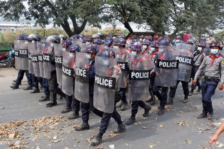 Police advance on the street during protests against the military coup, in Mandalay, Myanmar.