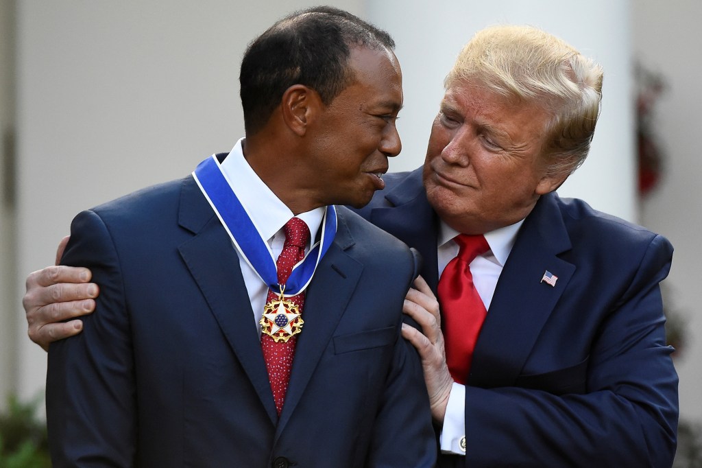 Golfer Tiger Woods reacts while being awarded the Presidential Medal of Freedom, the nation's highest civilian honor, by U.S. President Donald Trump