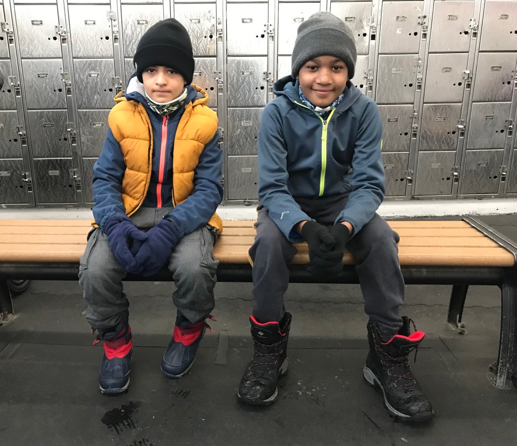 Ellis Santos (left) and Josh Eichinger, 10 (right) in the locker room after playing hockey at Wollman rink.