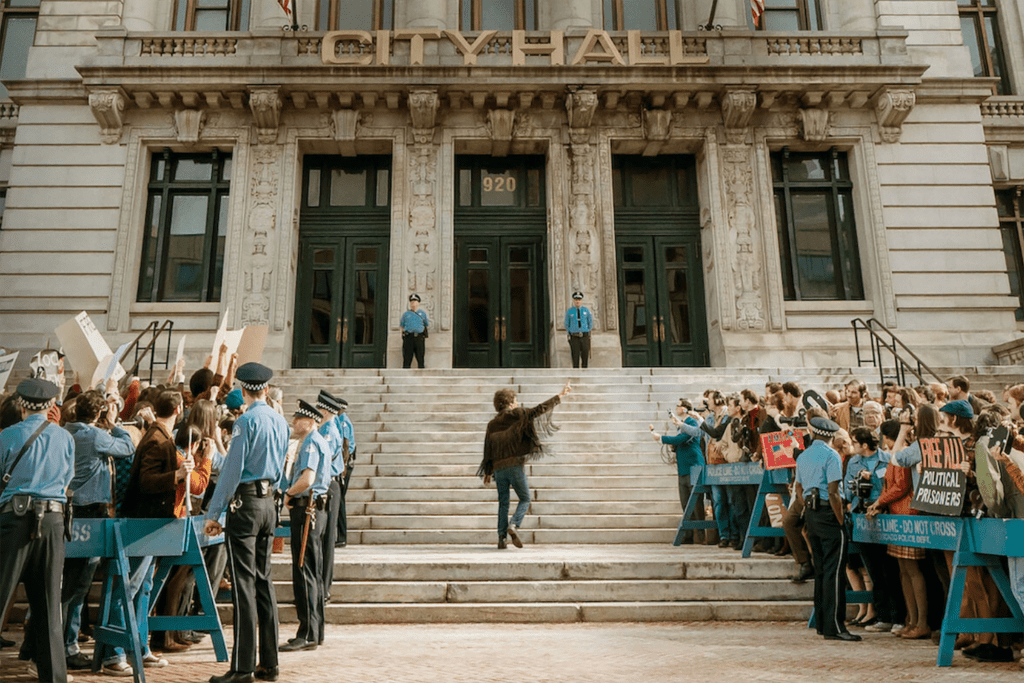 A man walks up the steps to city hall with police and crowds on either side 