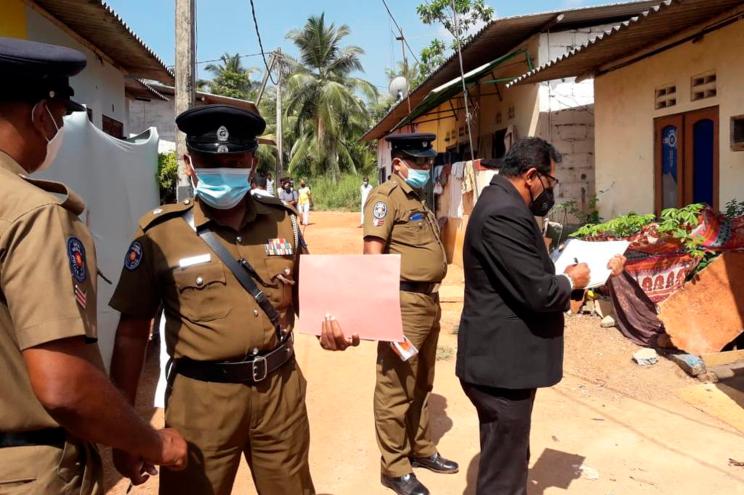 Sri Lankan magistrate Wasantha Ramanayake (right) and police officers at the house wehre the girl died during an exorcism on February 28, 2021.