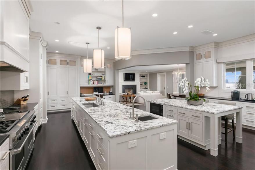 A gourmet chefs kitchen with two white marble islands.