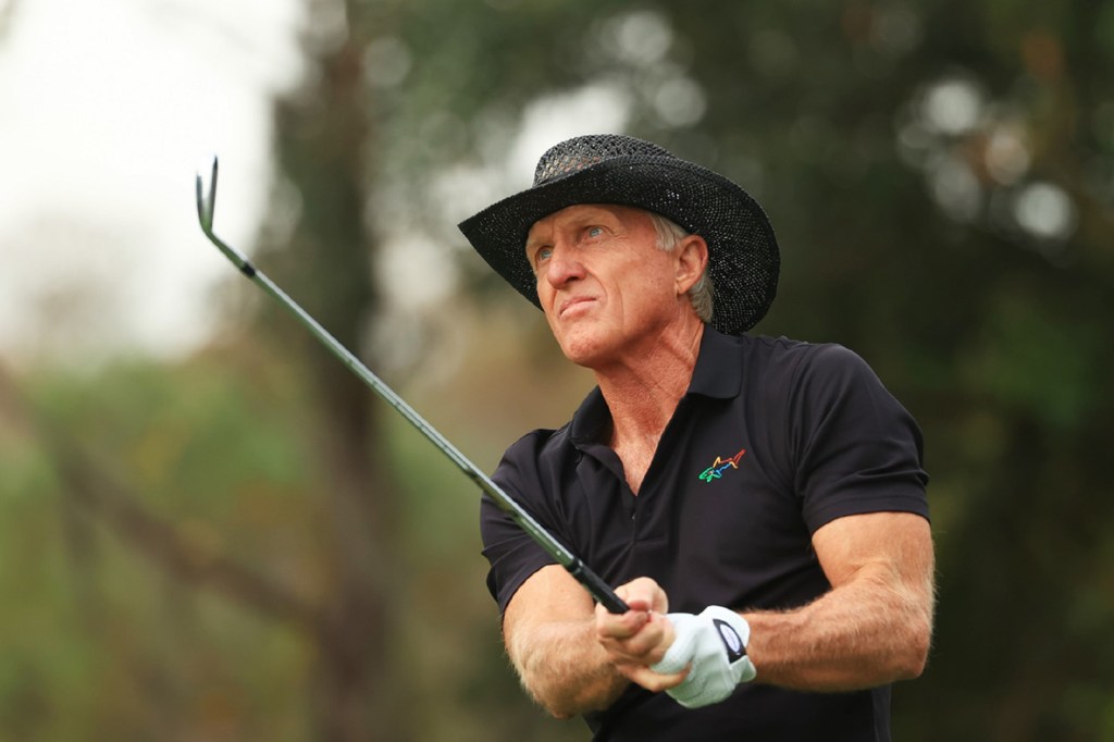 Greg Norman playing a shot on a golf course.  