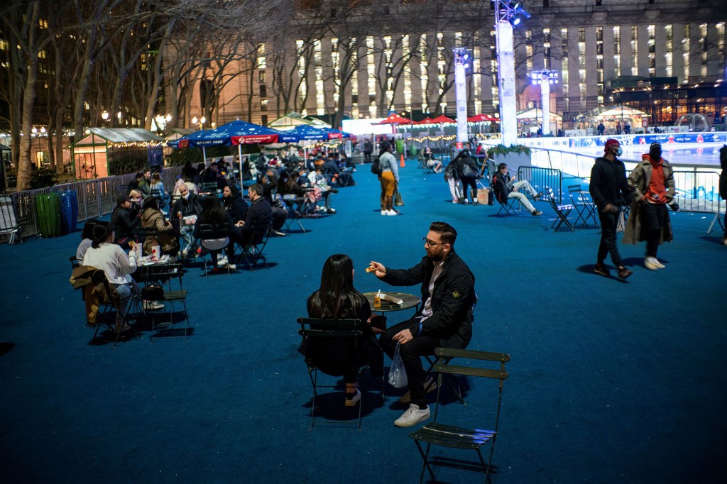 People enjoy the weather outside at Bryan Park