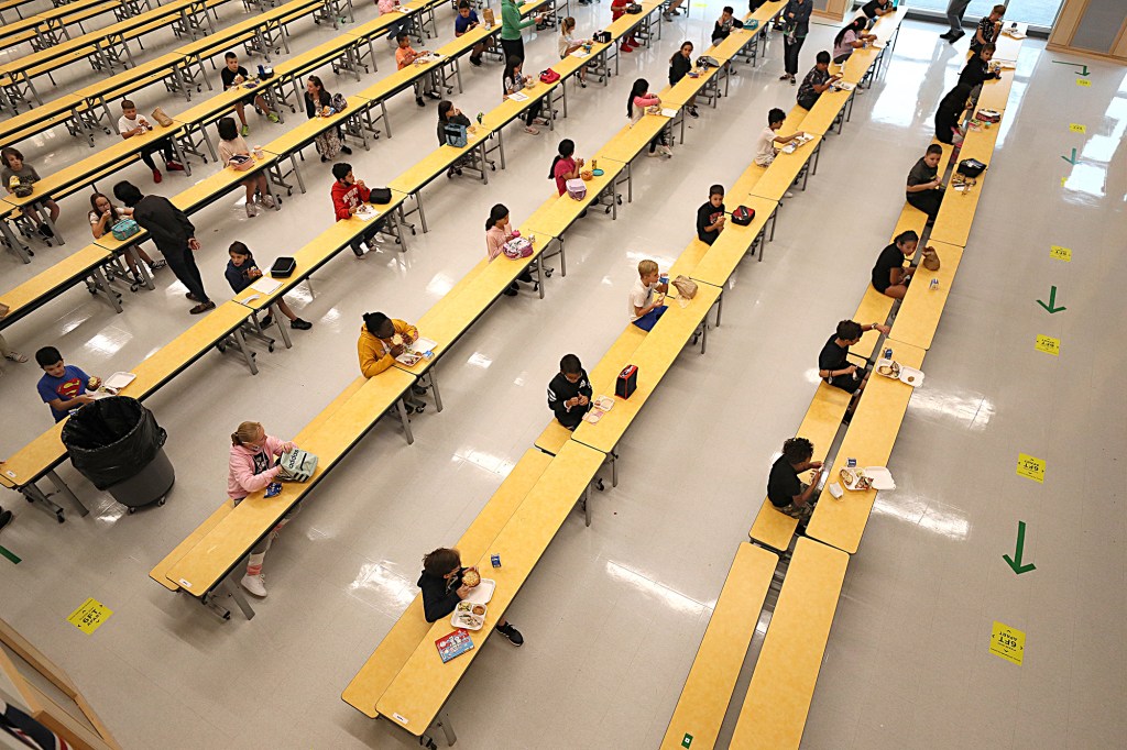 School children are spaced apart in one of the rooms used for lunch at Woodland Elementary School in Milford, Mass. on Sept. 11, 2020.