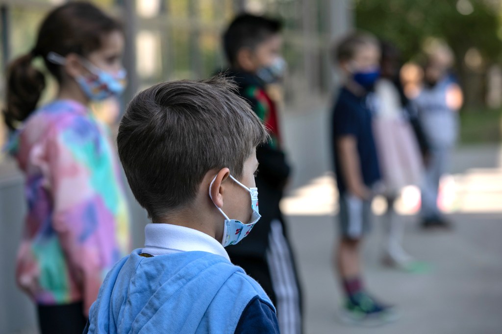 Masked school children wait to have their portraits taken during picture day at Rogers International School on Sept. 23, 2020 in Stamford, Conn.