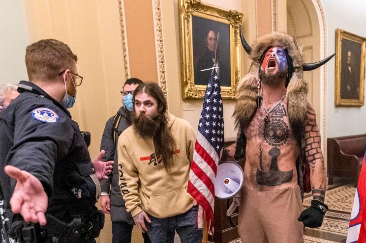 Supporters of President Donald Trump, including Jacob Chansley, right with fur hat, are confronted by US Capitol Police officers outside the Senate Chamber.