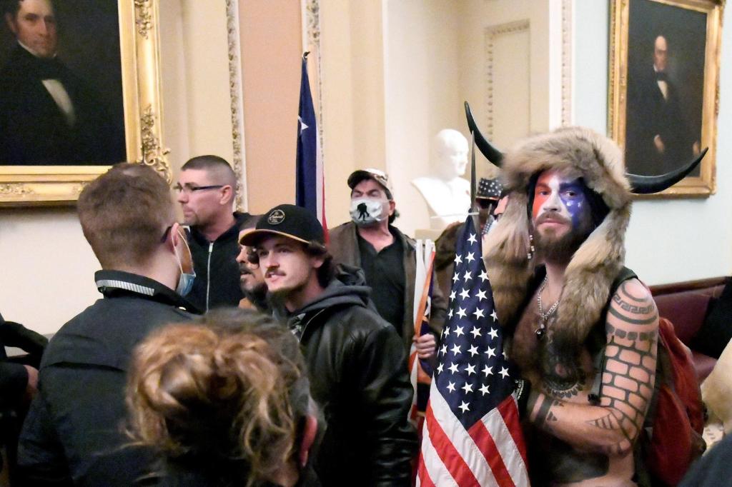 Jacob Chansley stands with other supporters of President Donald Trump as they demonstrate on the second floor of the US Capitol.