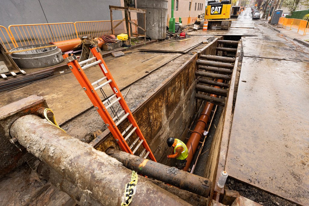 Workers are seen on the site of a sewer line replacement project in Queens on April 15, 2021.