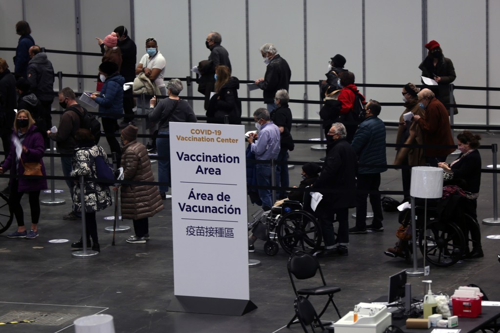  People wait inside Manhattan’s Javits Center in NYC for a COVID-19 shot.