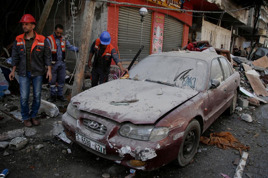 Palestinians inspect the damage from an early morning Israeli airstrike in Gaza City.