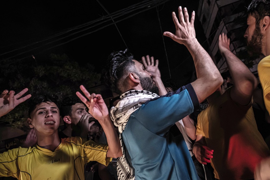 Palestinians celebrate the cease-fire agreement between Israel and Hamas on May 21, 2021 in Gaza City.