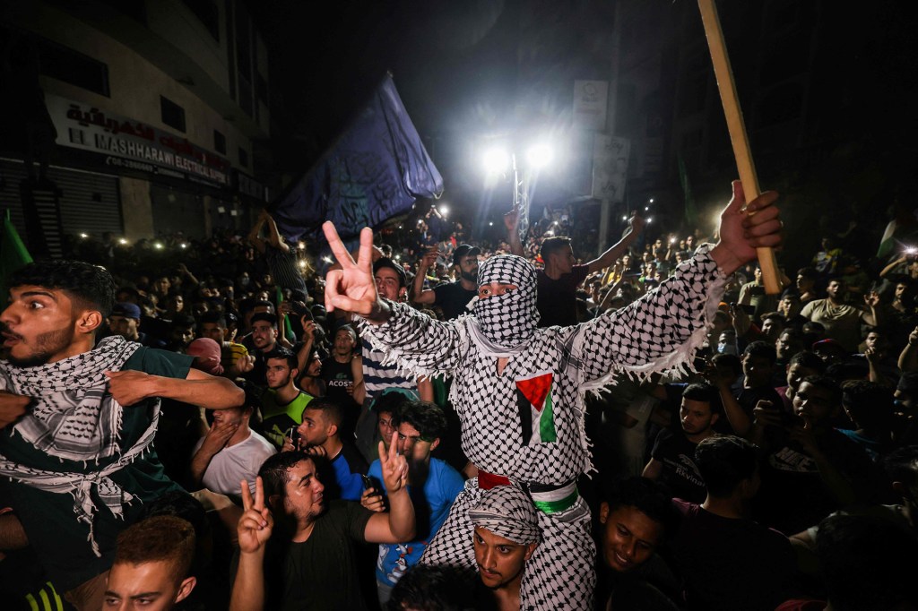 Palestinians celebrate in the streets following a ceasefire brokered by Egypt between Israel and Hamas.