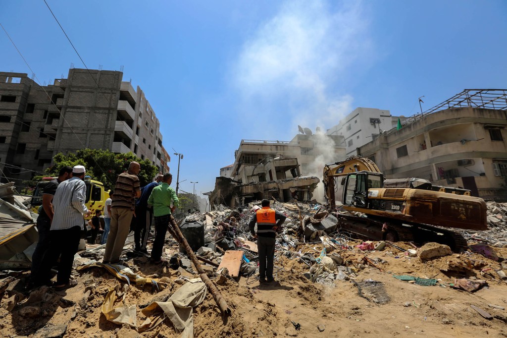 Palestinians search for victims under the rubble of a destroyed building in Gaza City's Rimal residential district following massive Israeli bombardment on the Hamas-controlled enclave on May 16, 2021.