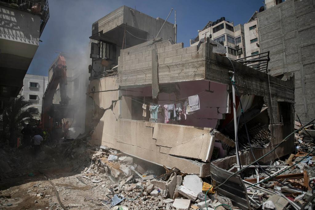 Palestinian rescuers search for survivors under the rubble of destroyed residential buildings following deadly Israeli airstrikes in Gaza City