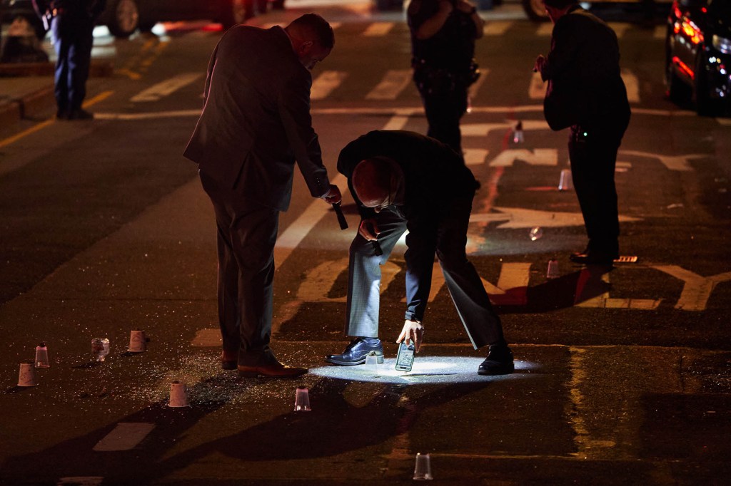 Members of the New York Police Department investigate the scene of a triple-shooting near 2289 5th Avenue in Harlem, on May 7, 2021.