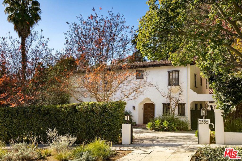 The exterior is unaltered since its ownership under Larry Fine, from the deep carved doorway and heavy wooden door to the balcony overlooking the fountain in the motor court, historical photos show.