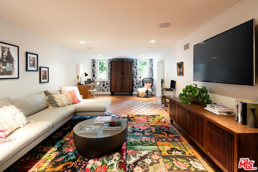 Below the ground floor, a semi-basement has a family room with red terracotta floor tiles.
