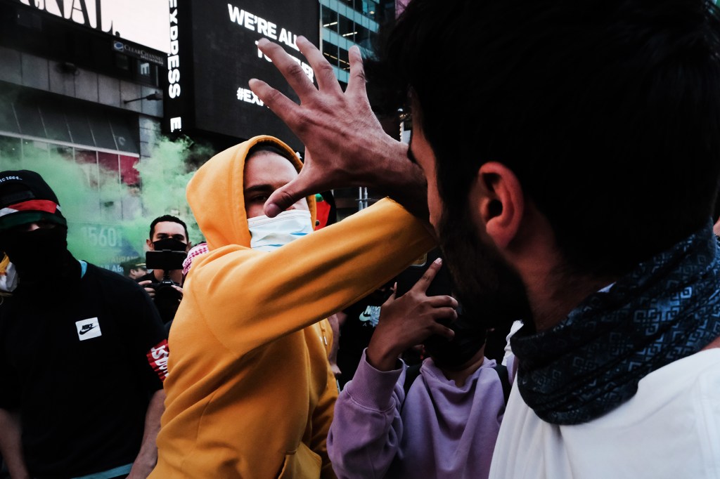 Pro-Palestinian protesters face off with a group of Israel supporters and police in a violent clash in Times Square