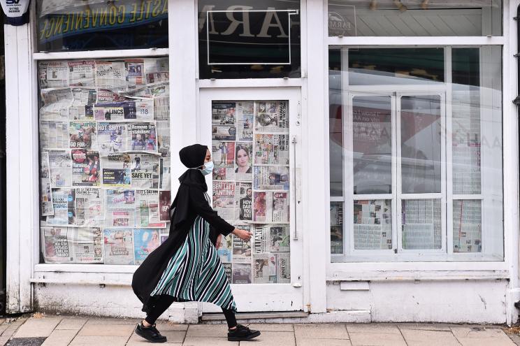 A woman walks by a closed shop on May 12, 2021 in Newcastle-Under-Lyme, England. Some abandoning of masks will begin on May 17.