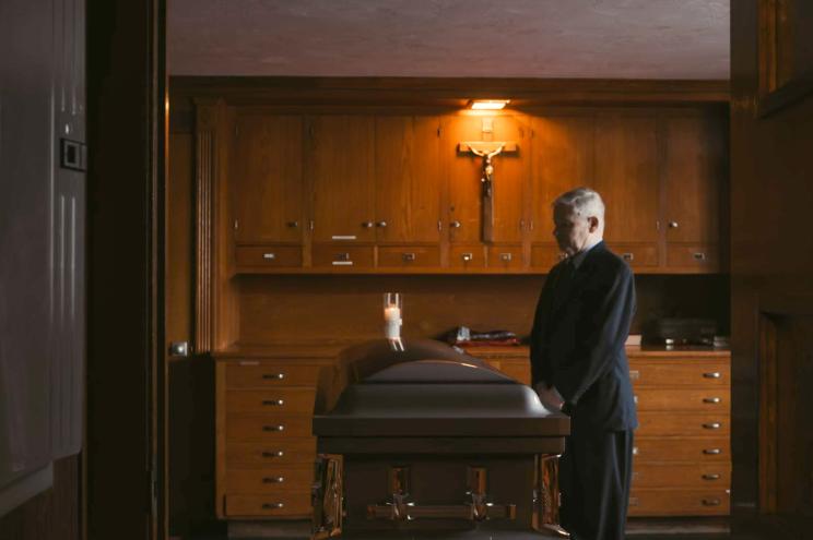 Photo of William Bulger standing in front of the coffin of his brother, Whitey Bulger.